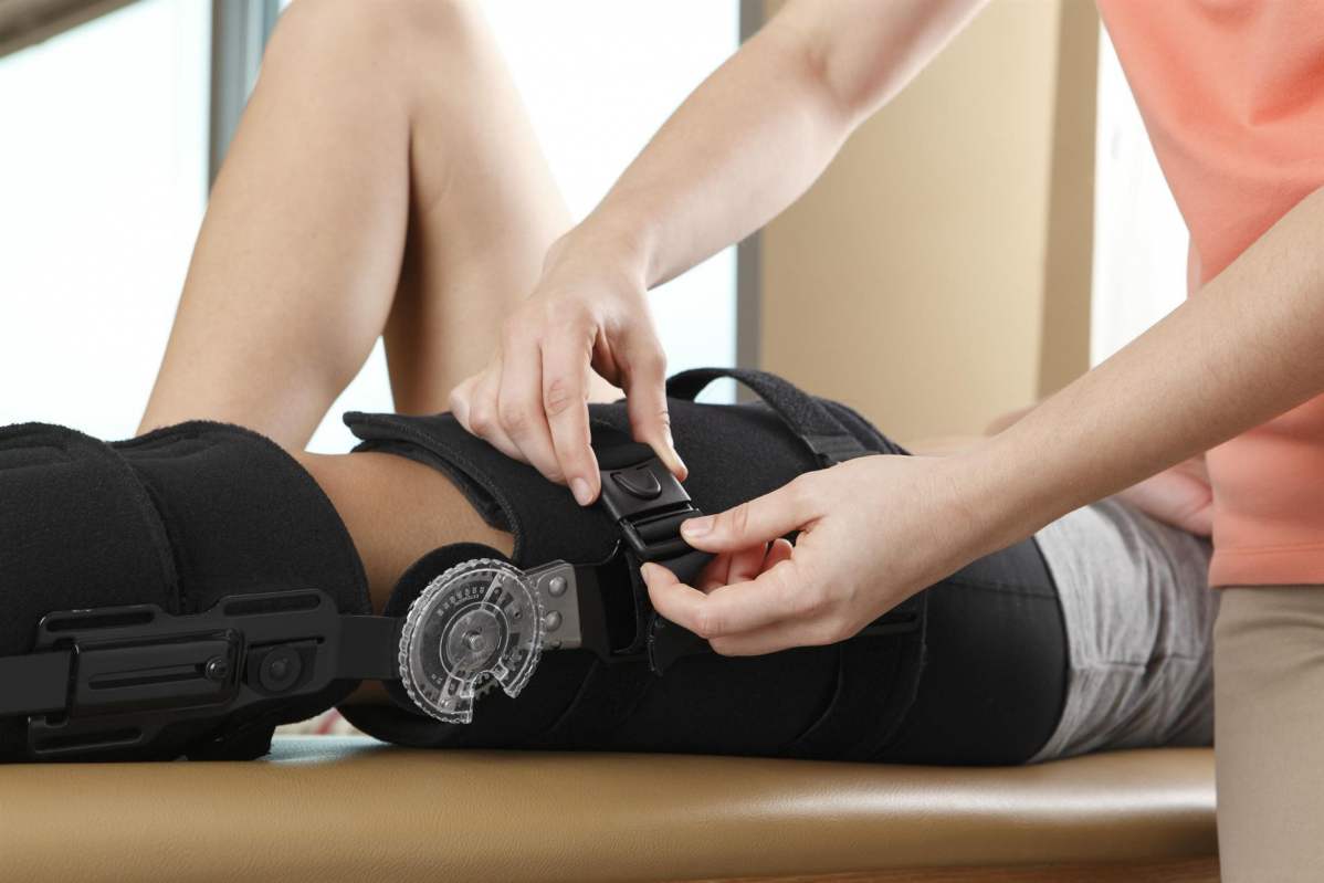 Foto: Einem Patienten wird eine Beinschiene für das sicherere Laufen angebracht