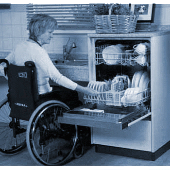 Frau im Rollstuhl räumt Geschirrspülmaschine aus, die höher eingebaut ist. Somit kann sie die Maschine gut ausräumen