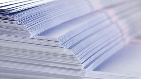 Foto: Ein großer Stapel frischgedruckter Flyer in der Seitenansicht