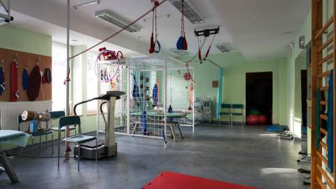 Foto von einem großen Therapieraum. U.a. mit Gangtrainer, Sprossenwand, Bopart-Liege u.v.m.