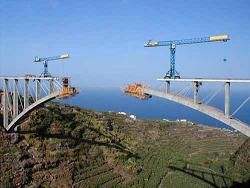 Foto: Auf einer Brückenbaustelle wachsen beide Brückenseiten über einem Tal zusammenn